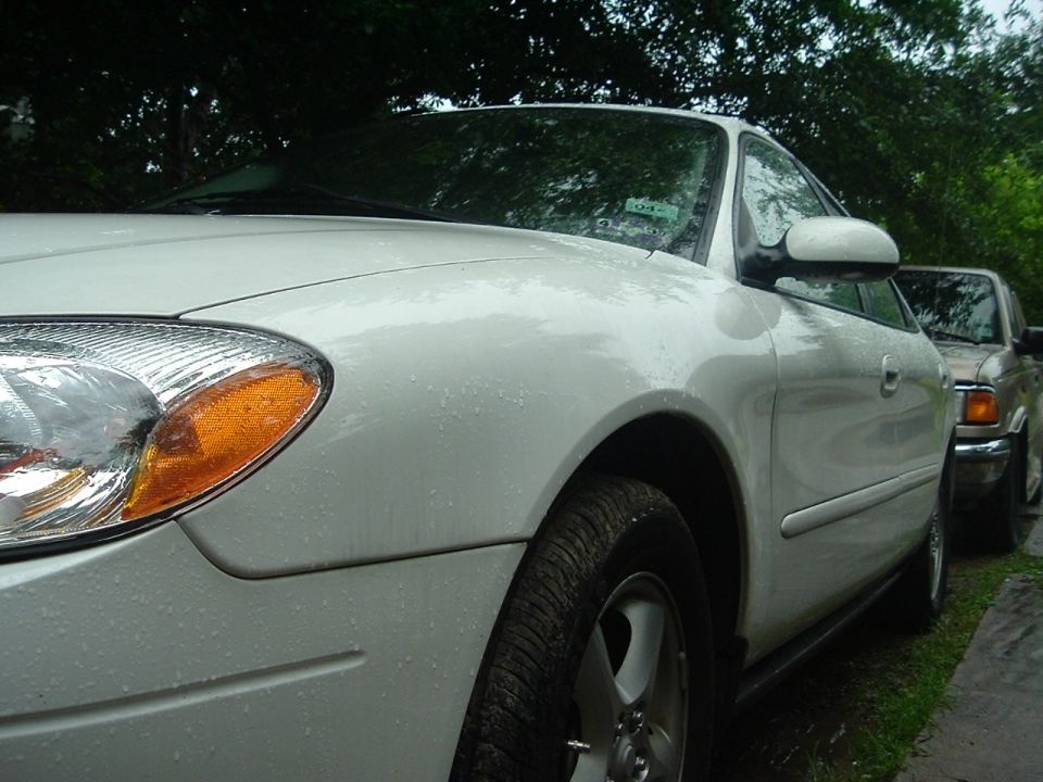 White 2003 Ford Taurus, 3/4 front view. Another vehicle is parked behind it