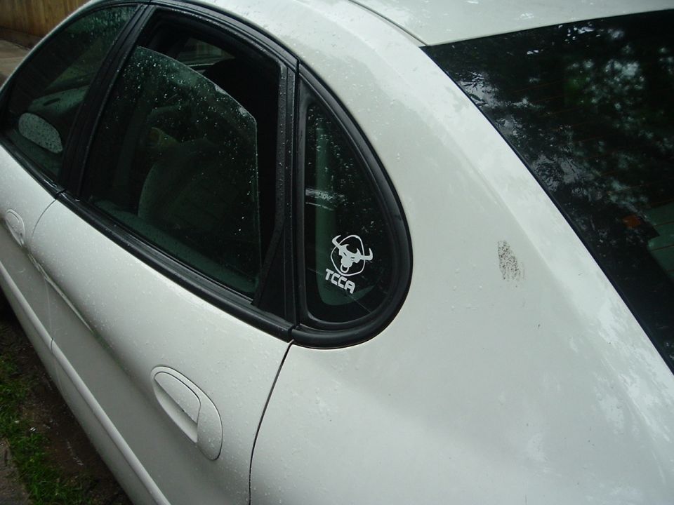 2003 Ford Taurus side view showing rear quarter panel with a TCCA bull sticker on the rear window