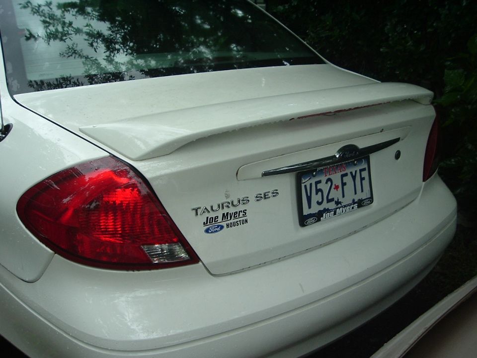 Rear of white 2003 Ford Taurus SES with spoiler and Texas plates V52-FYF