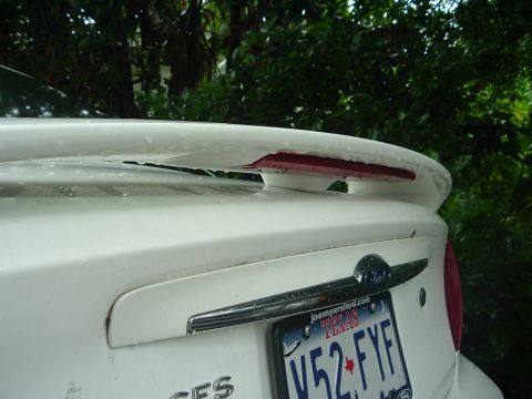 2003 Ford Taurus - The rear of a white 2003 Ford Taurus, showing the spoiler and license plate.