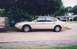 2003 Ford Taurus - A side view of a sedan parked outdoors, with trees and foliage visible.