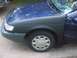 1993 Ford Taurus - A close-up view of the front quarter panel and wheel of a blue car.