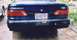 1993 Ford Taurus - The rear view of a dark-colored sedan is shown, its taillights and license plate.
