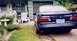 1993 Ford Taurus - A dark blue sedan is parked in a driveway, showing damage to its rear bumper.