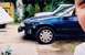 1993 Ford Taurus - A blue sedan is seen from the side, with another vehicle partially visible behind it and a person's face in the foreground.