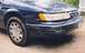 1993 Ford Taurus - The rear passenger side of a dark blue sedan is shown, focusing on the taillight and wheel.