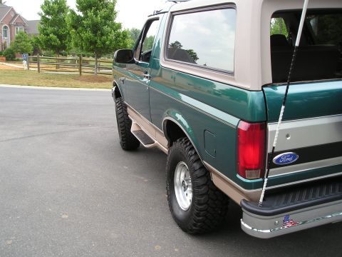 1996 Ford Bronco - This lifted 1996 Ford Bronco features a two-tone green and tan paint scheme and prominent off-road tires.
