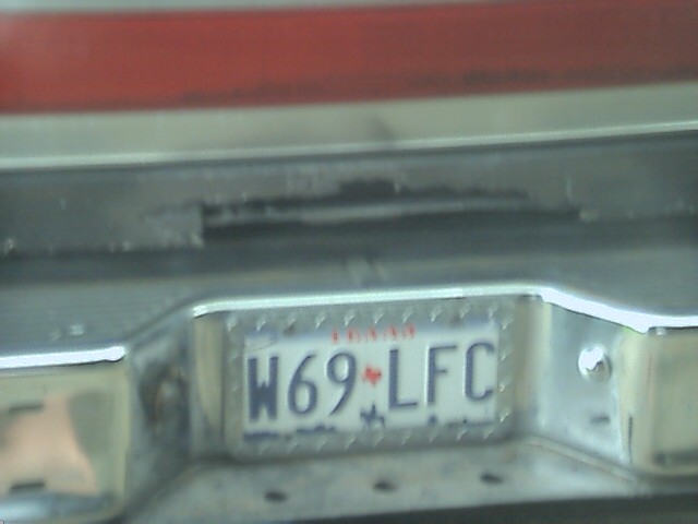 License plate W69-LFC on a chrome bumper, with red paint above