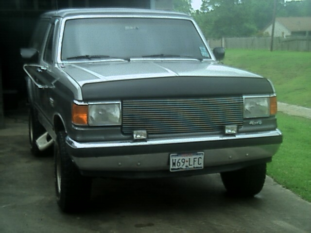 Front view of gray Ford Bronco with new billet grille insert and black hood bra