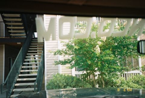1988 Ford Bronco - Reflection on the windshield shows text and an outdoor scene with an apartment building and stairs.