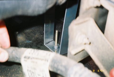 1988 Ford Bronco - A metal bracket assembly with a bolt and pin is visible in this close-up view.