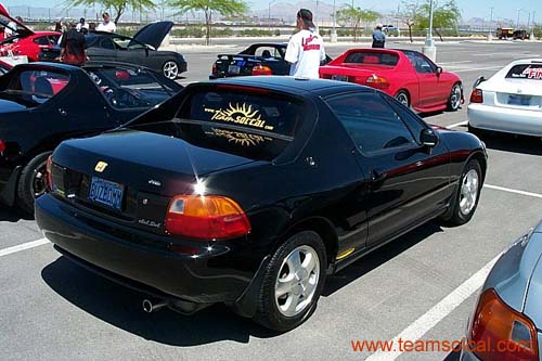 Black Honda Civic del Sol coupe parked rear three-quarter at a car show lot