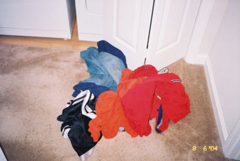 1988 Ford Bronco - A pile of laundry sits on a carpeted floor next to a white door and a large white appliance.