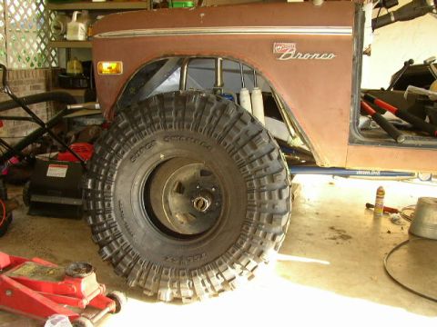 1995 Ford Bronco - This 1974 Ford Bronco is shown with a large off-road tire and other equipment in a garage setting.