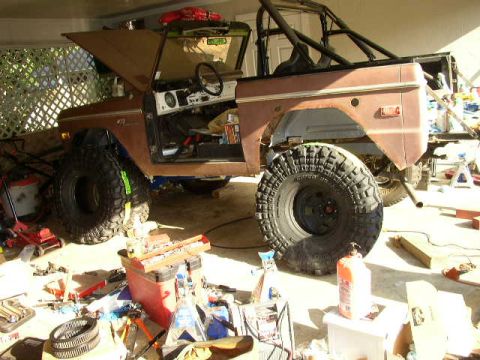 1995 Ford Bronco - This modified SUV, likely a 1978 Ford Bronco, is shown with its hood open and large off-road tires, suggesting it is undergoing maintenance…