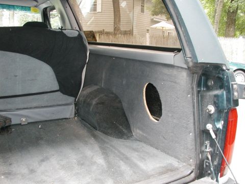 1994 Ford Bronco - The interior cargo area of a 1994 Ford Bronco shows a speaker cutout on the side panel.