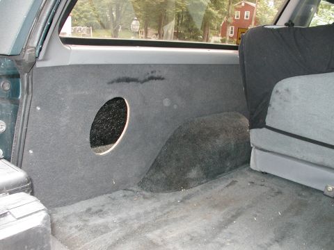 1994 Ford Bronco - Vehicle's rear interior cargo area with a custom speaker cutout in the paneling.