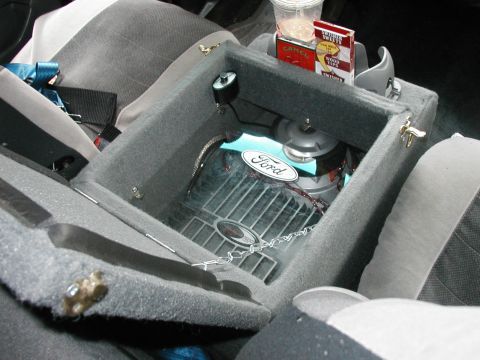 1994 Ford Bronco - Interior view of a 1994 Ford Bronco, showing the center console with an open compartment and various items inside.