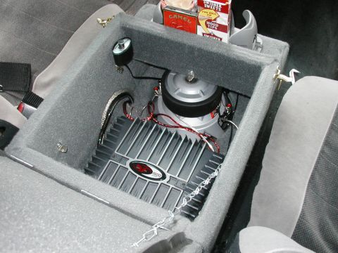 1994 Ford Bronco - Custom center console houses a subwoofer and amplifier, with a pack of Camel cigarettes on top.