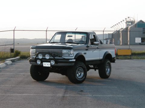 1994 Ford Bronco - This lifted 1994 Ford Bronco features a two-tone paint scheme and aftermarket accessories, including a bull bar and auxiliary lights.