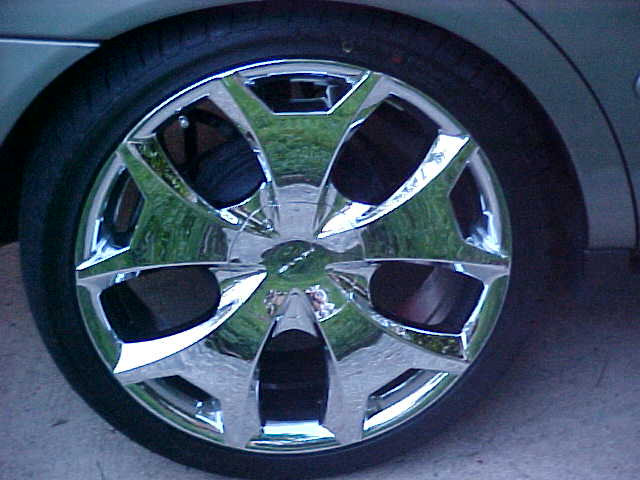 Chrome multi-spoke wheel with low-profile tire on a silver sedan