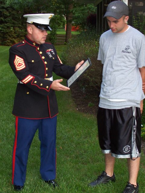 1994 Ford Bronco - A Marine presents a framed document to another man outdoors.