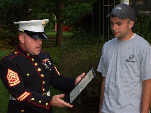 1994 Ford Bronco - A Marine presents a framed document to a civilian outdoors.