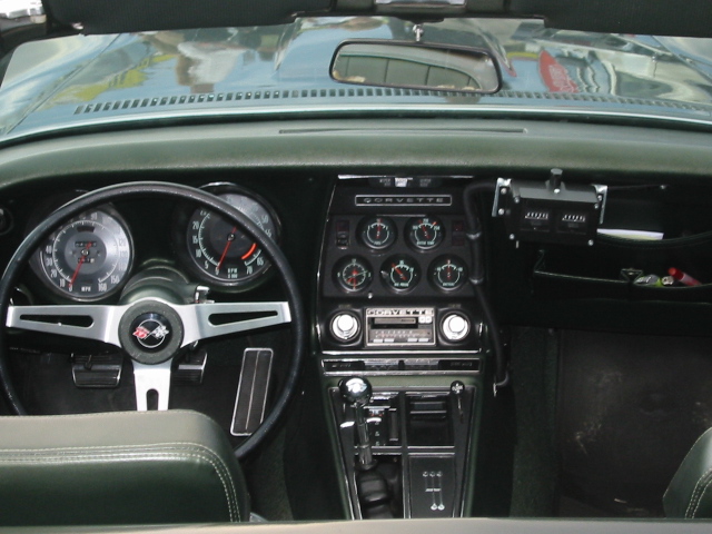 1969 Corvette interior showing steering wheel, gauges, and center console with radio
