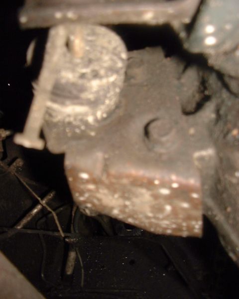 1985 Ford F-150 - A close-up view of a worn and rusty mechanical component, likely part of a vehicle's undercarriage.