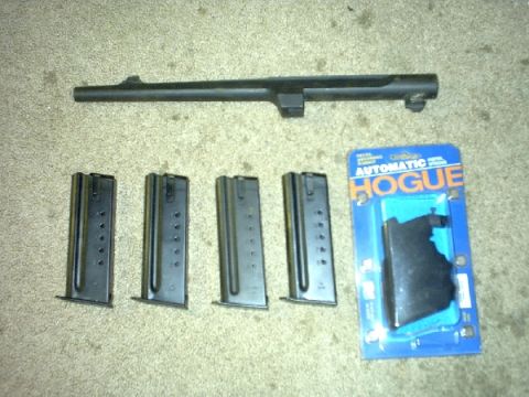 1995 Ford Bronco - Gun parts including a barrel, magazines, and a Hogue grip are laid out on a carpeted surface.