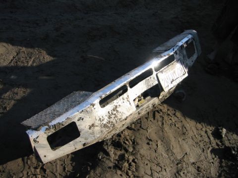1985 Ford Bronco - A muddy chrome bumper with a license plate is visible on the ground.
