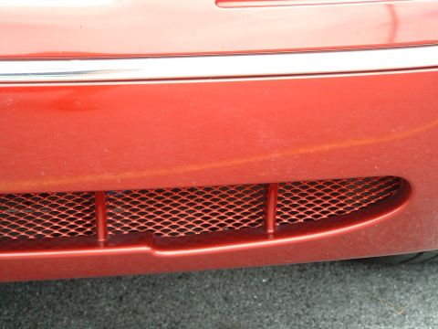 1999 Ford Crown Victoria - Close-up of the front grille and bumper area of a red 1999 Ford Crown Victoria.
