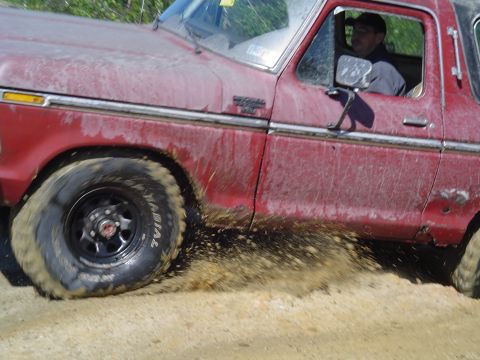 1993 Ford Bronco - A red 1978 Ford Bronco kicks up mud as it drives off-road.