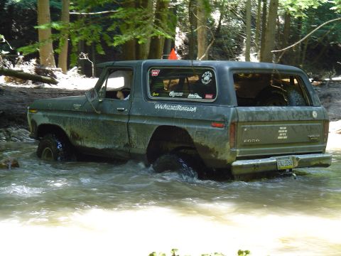1993 Ford Bronco - This Ford Bronco is navigating a water obstacle in a wooded area.