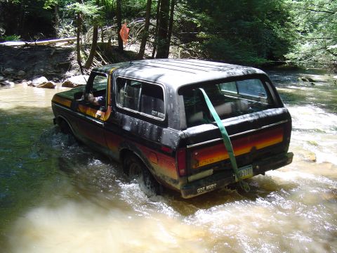 1993 Ford Bronco - This Ford Bronco navigates a stream, its rear end visible as it splashes through the water.
