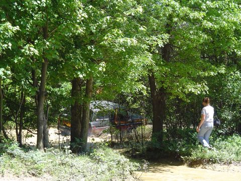 1993 Ford Bronco - Off-road vehicle stuck in mud, with trees and a person observing the scene.