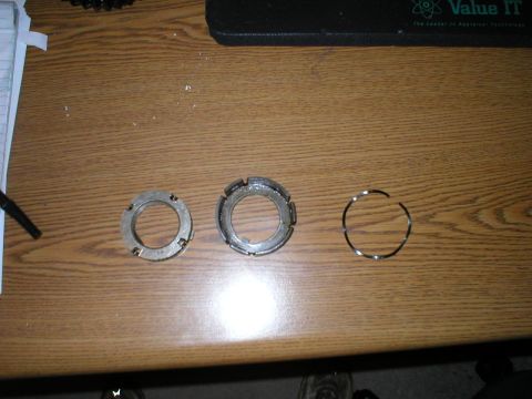 1986 Ford Bronco - Three metal rings, possibly automotive parts, are displayed on a wooden surface.