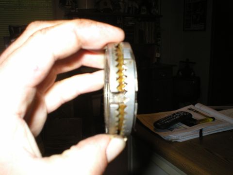 1986 Ford Bronco - Close-up of a mechanical part with visible teeth, held by a hand.