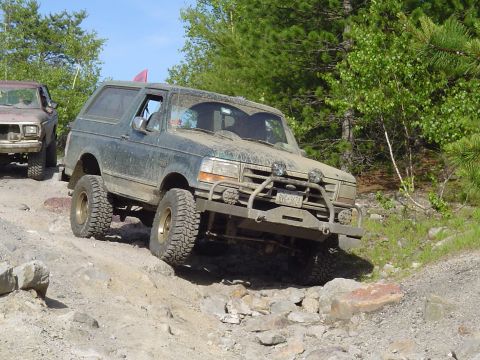 1993 Ford Bronco - This Ford Bronco is navigating a challenging off-road course with steep inclines and large rocks.