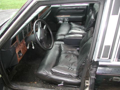 1987 Lincoln Town Car - Interior view of a 1987 Lincoln Town Car, showing plush leather seats and classic wood grain dashboard accents.