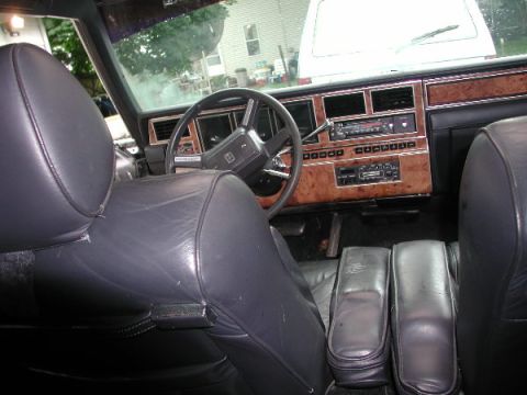 1987 Lincoln Town Car - The dashboard features wood grain trim and an old-school radio.