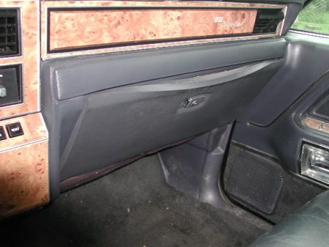 1987 Lincoln Town Car - Interior view of a 1987 Lincoln Town Car, highlighting the dashboard's wood grain trim and glove compartment.