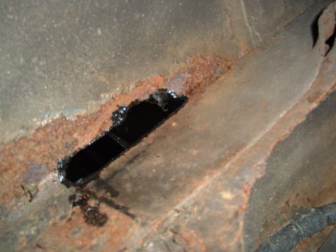 1993 Ford Bronco - The vehicle's frame shows significant rust and a hole, indicating potential structural damage.