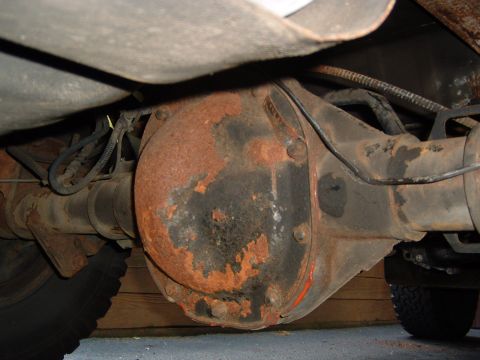 1993 Ford Bronco - Underside view of a heavily rusted rear differential and axle assembly.