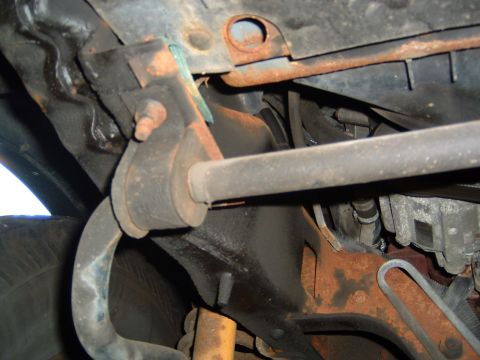 1993 Ford Bronco - Close-up view of the rusty undercarriage and suspension parts of a vehicle.