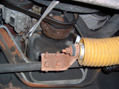 1993 Ford Bronco - Underside view of engine components including the oil pan, belts, and a yellow bellows hose.