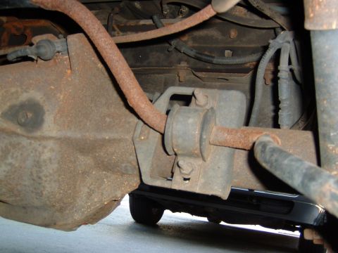 1993 Ford Bronco - Close-up view of the rear axle and suspension system, showing significant rust on various components.
