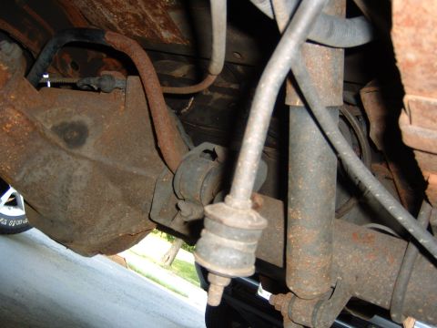 1993 Ford Bronco - Underside view of rusty rear axle and suspension parts, showing wear and tear.