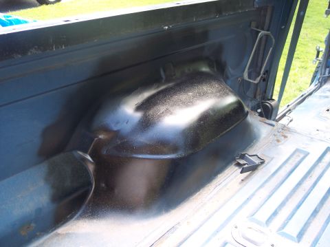 1990 Ford Bronco - The interior of a truck bed shows the rear wheel well and the ribbed floor panels.