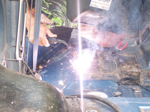 1990 Ford Bronco - A person welds inside a vehicle, with sparks illuminating the interior.